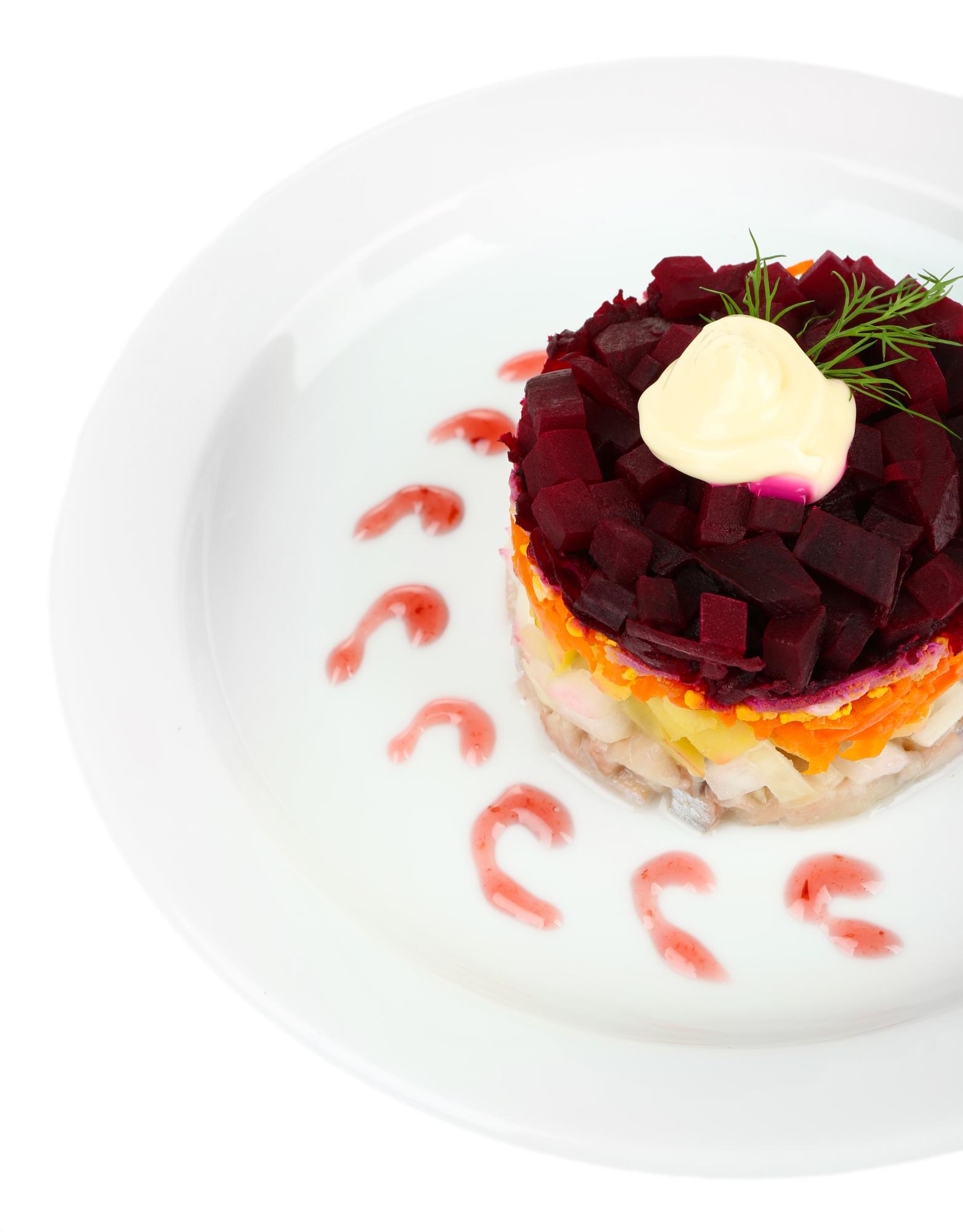 Chef plating a modern dish with bold garnishes